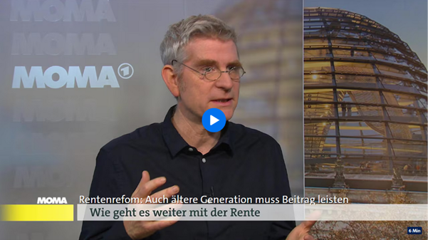 Peter Haan mit dem Logo des Morgenmagazins im Hintergrund. 