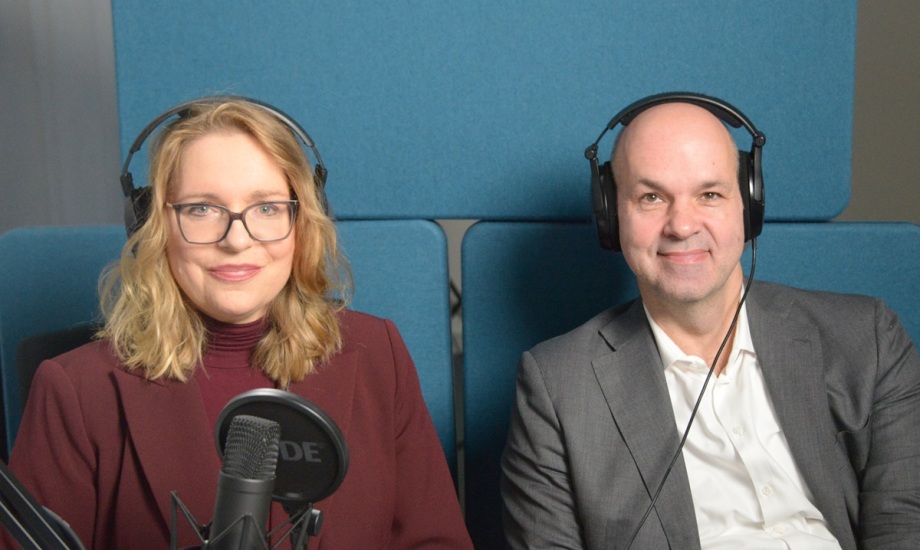 Claudia Kemfert und Marcel Fratzscher bei der Podcastaufzeichnung zum Thema Hate Speech und Wissenschaftsfeindlichkeit.; Auf dem Foto sitzen zwei Personen nebeneinander in einem Studio, beide tragen große schwarze Kopfhörer und blicken freundlich in die Kamera. Links sitzt eine Frau mit schulterlangem, welligem, blonden Haar, einer Brille mit dunklem Rahmen und einem bordeauxroten Blazer über einem passenden Rollkragenpullover. Das ist Claudia Kemfert. Vor ihr steht ein Mikrofon, das darauf hindeutet, dass sie an einer Aufnahme arbeitet. Rechts sitzt ein Mann mit Glatze, der einen grauen Anzug und ein weißes Hemd trägt. Das ist Marcel Fratzscher. Beide sitzen vor einer Wand aus blauen, gepolsterten Akustikelementen. Die Atmosphäre wirkt professionell und ruhig, als würden die beiden gemeinsam an einem Podcast oder einem Interview teilnehmen.