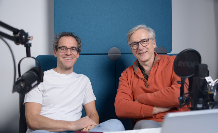 Auf dem Bild sind DIW-Forscher Wolf-Peter Schill (links) und der Journalist Erich Wittenberg zu sehen. Beide sitzen vor einer grünen Rückwand. Im Vordergrund sieht man zwei Mikrofone. 